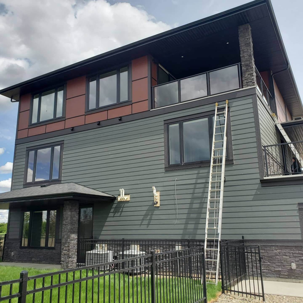 Clean Windows on Residential House With Ladder