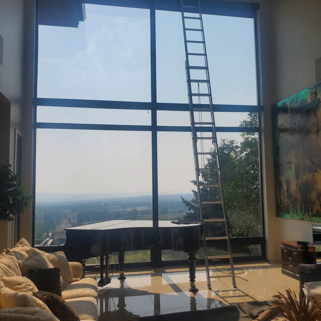Clean Windows on Residential House Inside With Ladder and Piano